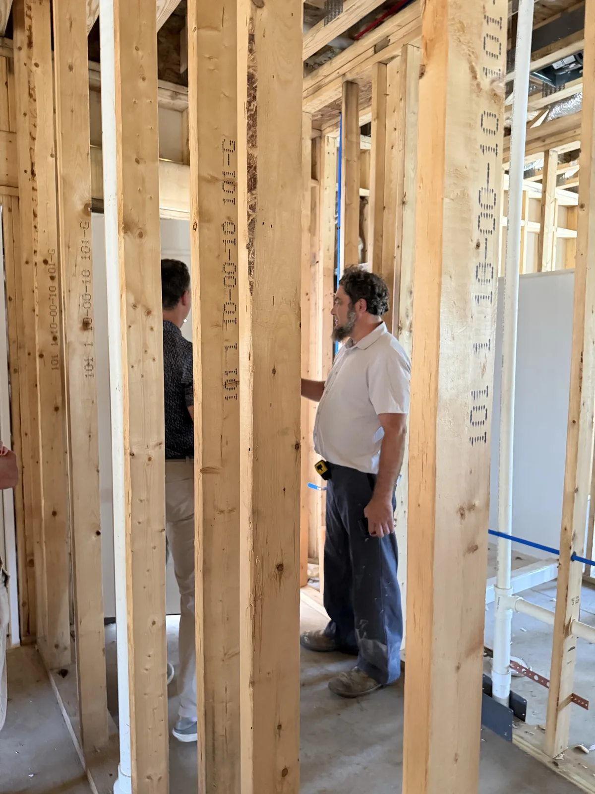 Real construction photo: plumbing supply and drain connections installed within the framed apartment interior at The Legacy at Richland Commons, September 8, 2026