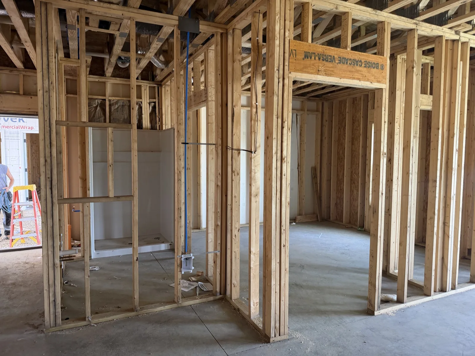 Real construction photo: framed bathroom and adjoining apartment rooms with a tub unit and utility rough-ins at The Legacy at Richland Commons, September 8, 2026
