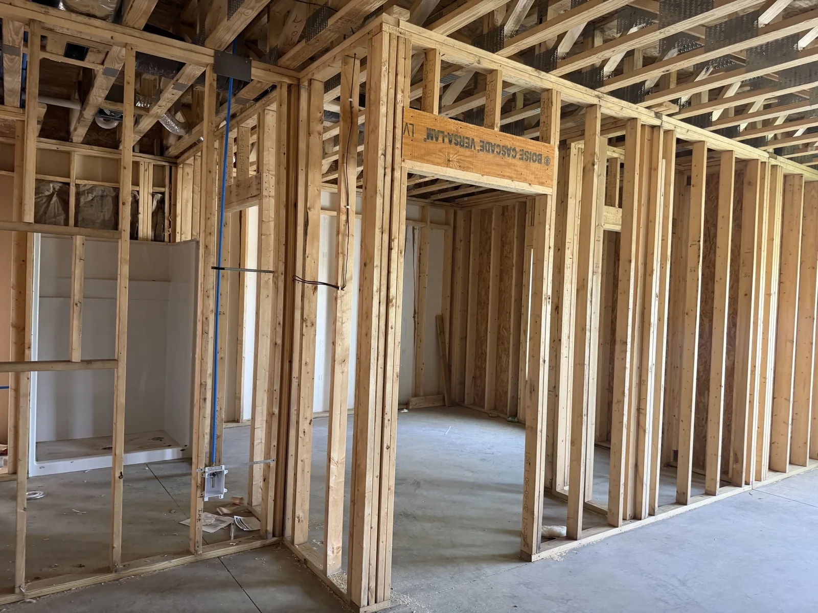 Real construction photo: interior apartment framing with plumbing, electrical, HVAC ductwork, and a tub unit visible at The Legacy at Richland Commons, September 8, 2026